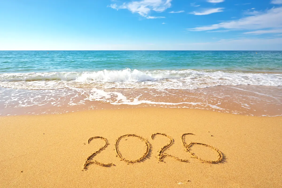 The year 2026 written in wet sand at the water's edge