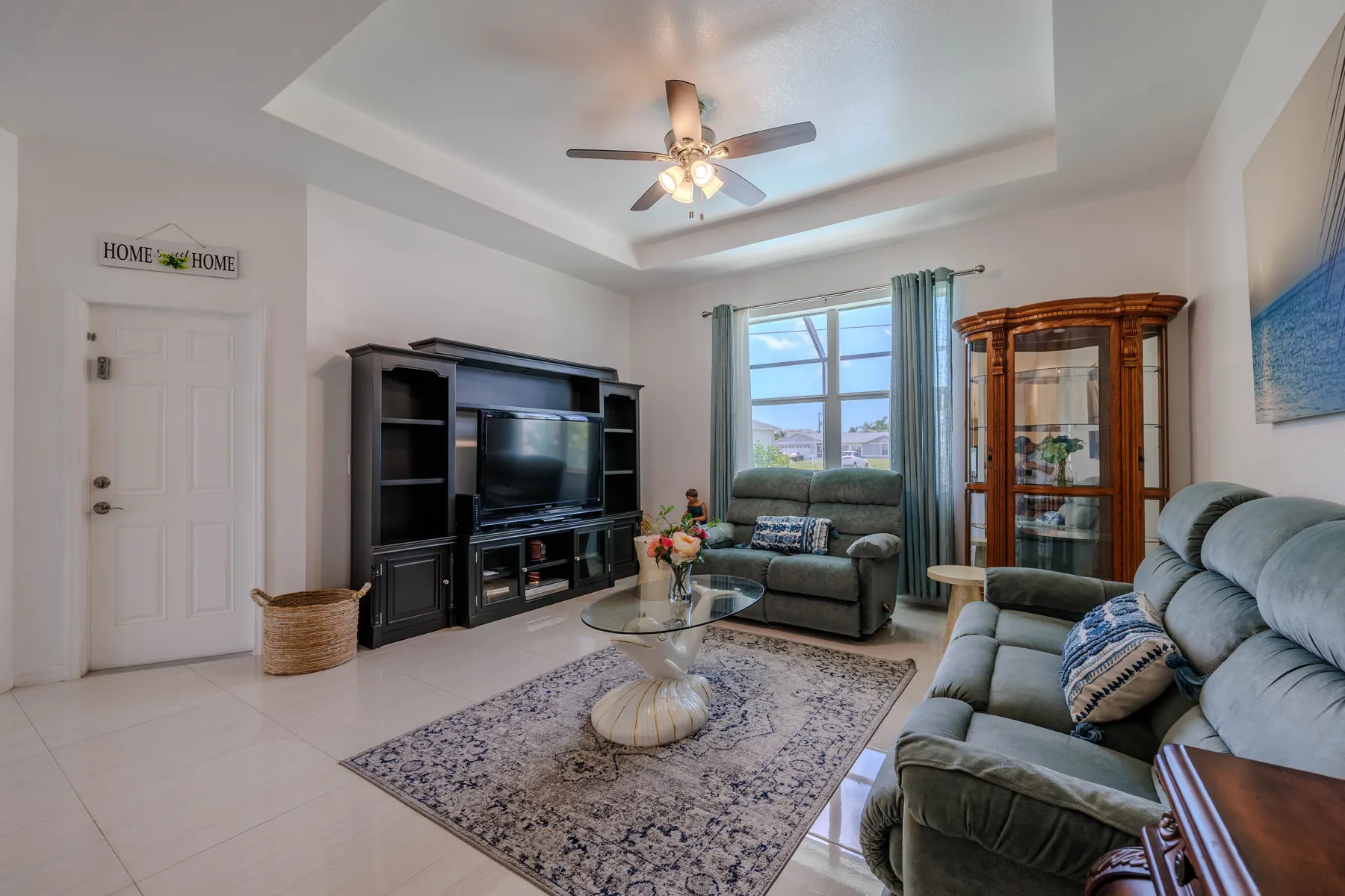 Family room with tray ceiling and ceiling fan
