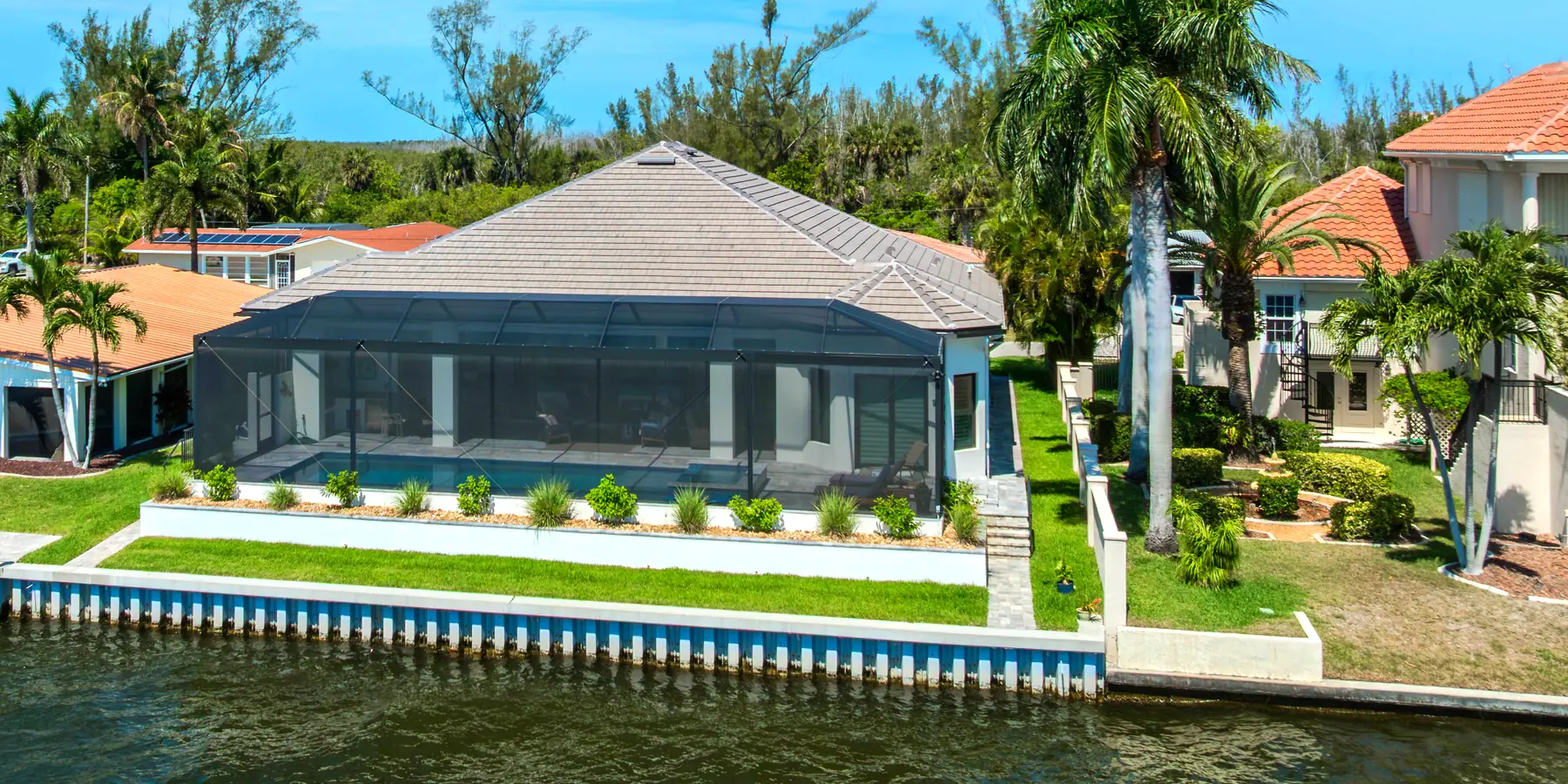 Cape Coral canal-front home with a concrete seawall and mature palms